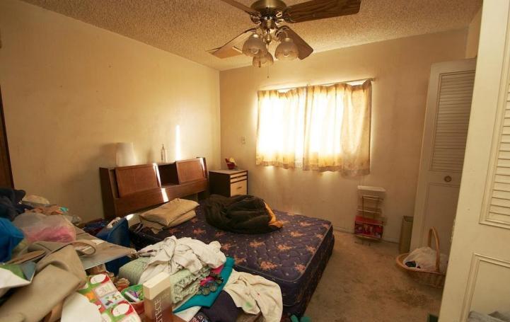 cluttered messy bedroom unmade bed soiled dirty stained carpet poor bad home staging Mesa Arizona house for sale
