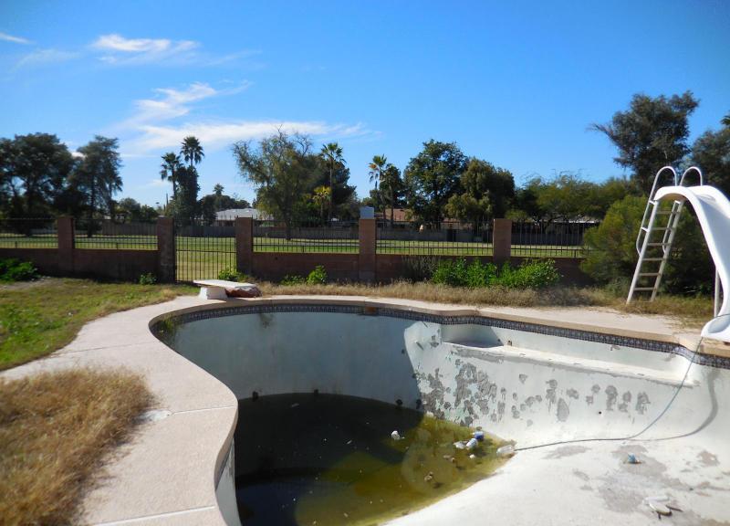 neglected damaged swimming pool with green algae water fixer-upper Mesa Arizona home house for sale photo