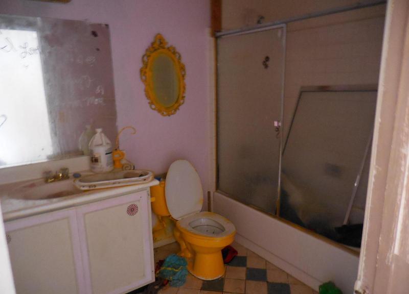 cluttered chaotic messy bathroom toilet painted orange shower doors broken fixer-upper Mesa Arizona home house for sale photo