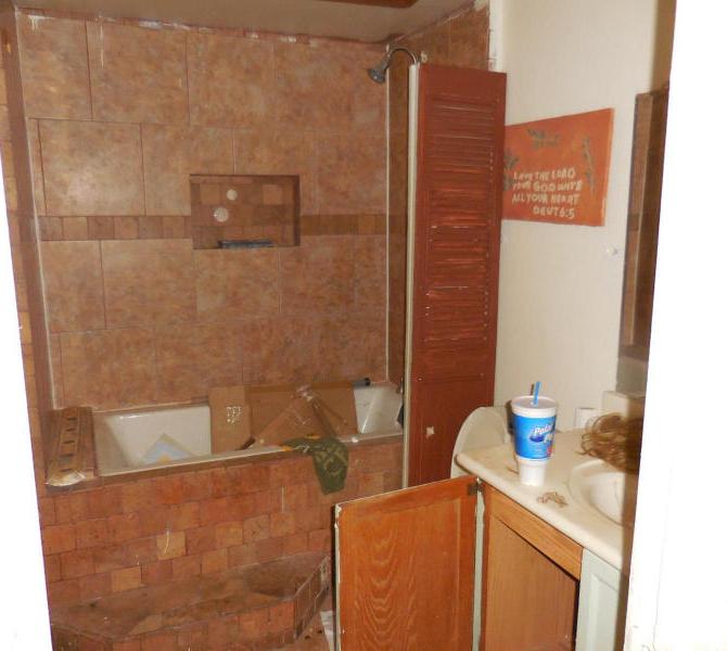 cluttered messy disorganized bathroom wig junk in bathtub fixer-upper Mesa Arizona home house for sale photo
