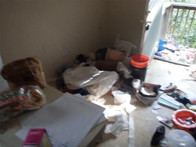 junk stuff garbage everywhere on floor chaotic bedroom fixer-upper Houston Texas home house for sale photo