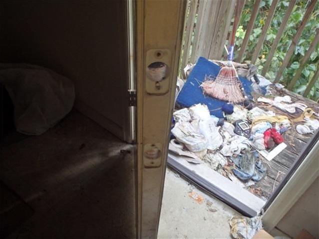 junk stuff garbage everywhere on floor porch outside fixer-upper Houston Texas home house for sale photo