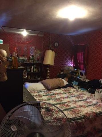 old vintage red velvet wallpaper cluttered chaotic messy disorganized bedroom San Diego California home house for sale real estate photo
