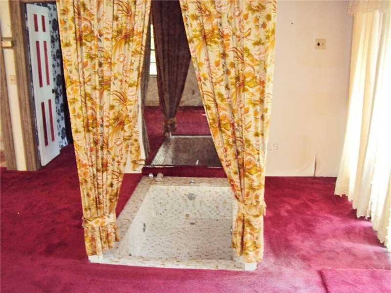 outdated ugly décor red carpet Roman sunken bathtub bathroom drapes mirror Dade City Florida home house for sale photo