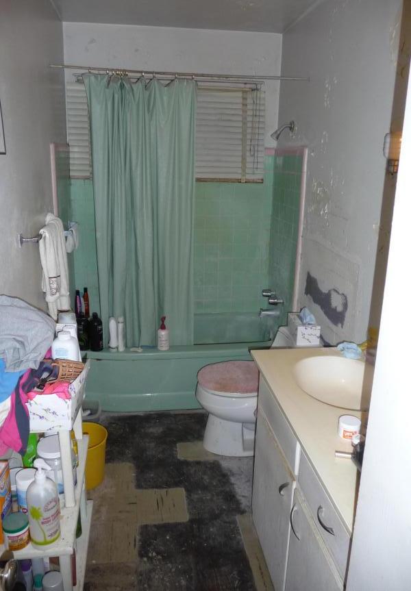 cluttered messy disorganized bathroom vinyl floor peeling missing too much stuff poor bad home staging Phoenix Arizona house for sale photo