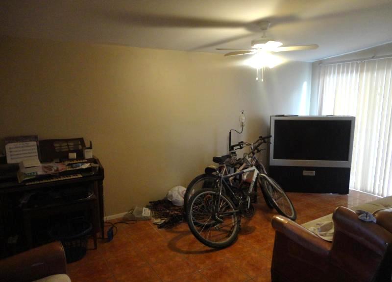 cluttered messy chaotic disorganized family room poor bad home staging organ bicycles Glendale Arizona house for sale photo