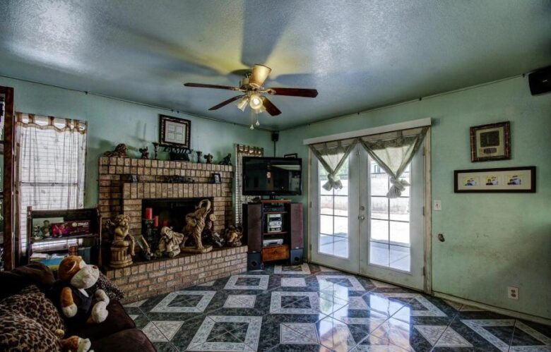 ugly floor tile pattern cluttered family room too much stuff statues poor bad home staging Phoenix Arizona house for sale knotted curtains