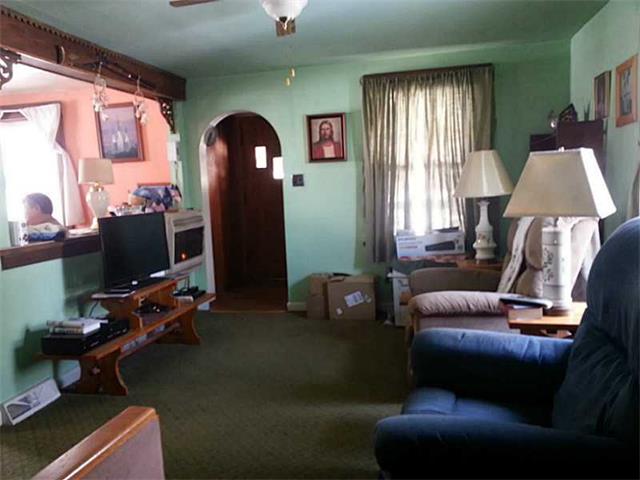 man person sitting rifle cluttered living room Grove City Pennsylvania home house for sale photo
