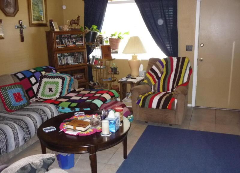 cluttered living room Afghan blankets poor home staging Glendale Arizona house for sale real estate photo