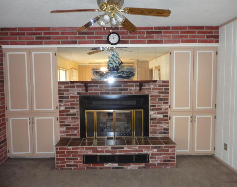 outdated fireplace screen brick surround brass ceiling fan Phoenix Arizona home house for sale real estate photo